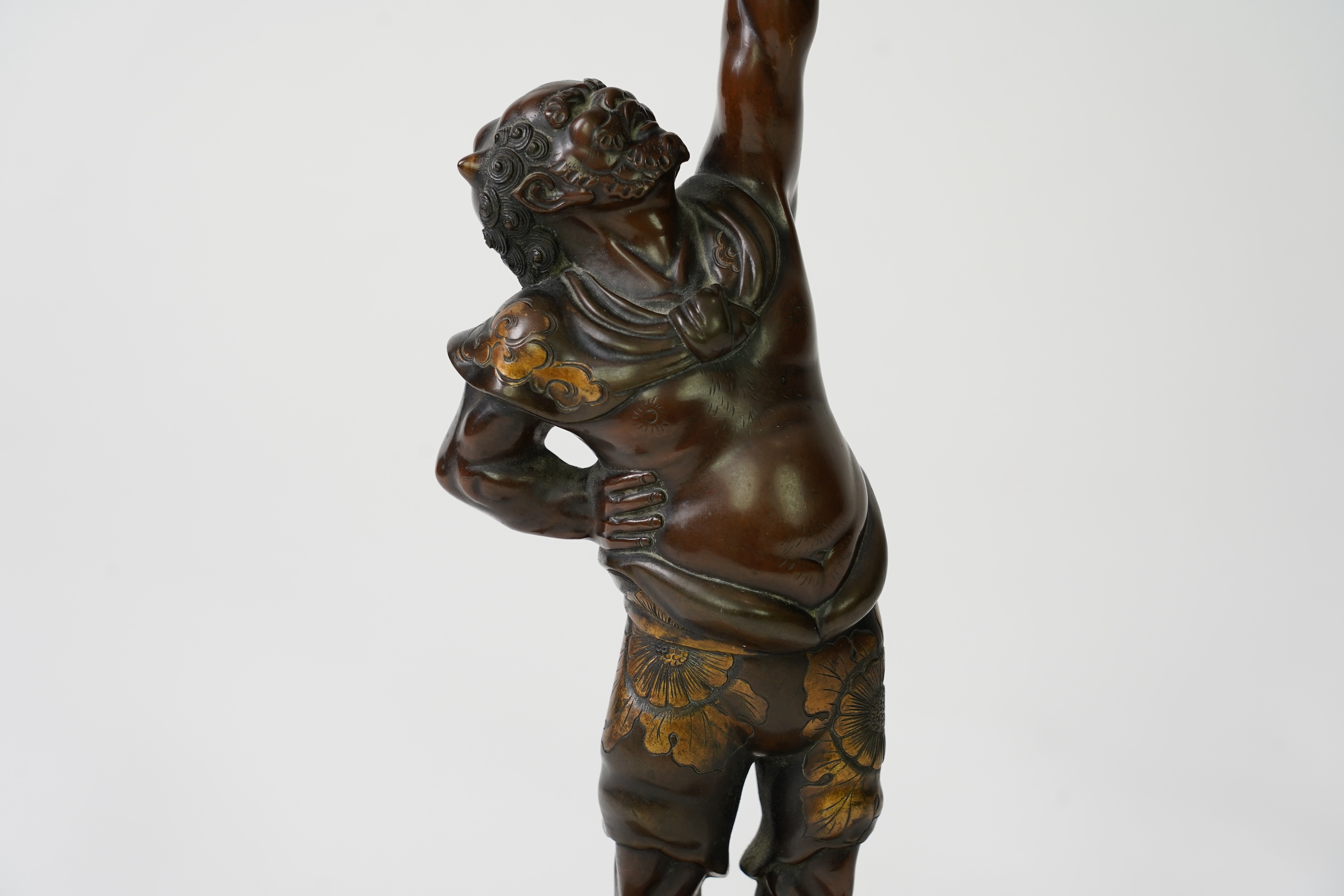 A Japanese bronze figure of an Oni holding a temple bell aloft, Meiji period, in Miyao style